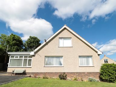 A house with three windows lawn and bench at Rose Bank in Belford