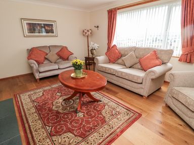 A living room with sofas a wooden coffee table and a patterned rug at Rose Bank in Belford