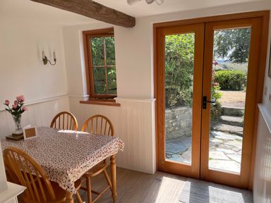 A dining room with a table and chairs at Bell Buoy Cottage in Morwenstow