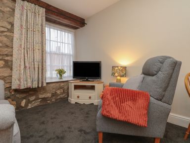 A living room with a television and armchair at Beck View