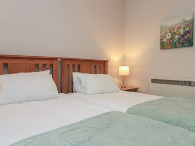A bedroom with two beds and a bedside lamp at Beck View