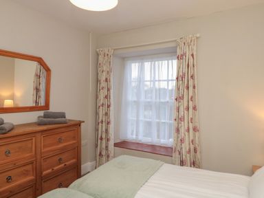 A bedroom with a bed, dresser, and window at Beck View