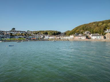 A coastal village with houses along the shoreline and hills in the background at Hyfrydle in Borth-Y-Gest