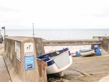 A boat ramp with small boats and signs near the sea at Ellan Vannin in Sheringham