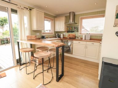 A kitchen with wooden stools and a wooden counter at 3 Valley View Lodges Nawton near Helmsley