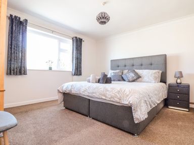 A bedroom with a double bed bedside table window and curtains at Summerhayes Park Bottom