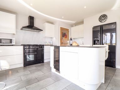 A kitchen with black stove oven white cabinets black refrigerator and a kitchen island at Summerhayes Park Bottom