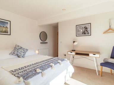 A bedroom with a bed a desk a chair and framed pictures on the walls at The Croft in Thompson near Watton