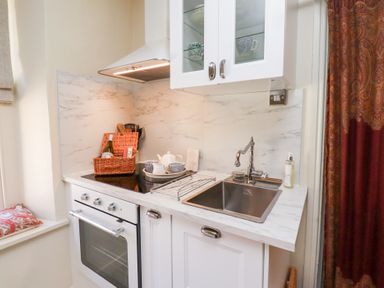 A kitchen with a stove oven sink and a basket on the counter at Beals Yard in Alnwick