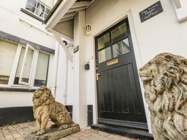 The black front door with two stone lion statues outside at The Town House in Dorchester