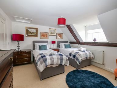 A bedroom with two single beds and bedside tables with lamps at The Town House in Dorchester
