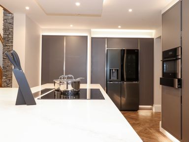 A modern kitchen with a knife set pot on stove black refrigerator and built in oven