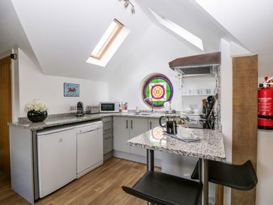 A kitchen with granite countertops round stained glass window and appliances at The Coach House in Ludlow