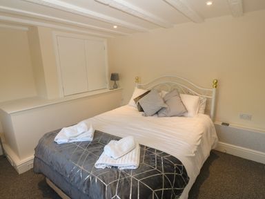 A bedroom with a double bed with pillows and towels on the bed at Plas Eithin in Mynydd Mechell near Llanfechell