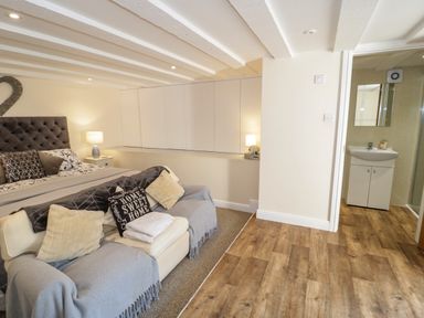 A bedroom with a bed sofa pillows and an adjoining bathroom at Plas Eithin in Mynydd Mechell near Llanfechell