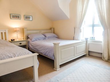 A bedroom with two beds a bedside table with a lamp and framed pictures on the wall at Beach View in Duncannon near Ramsgrange County Wexford