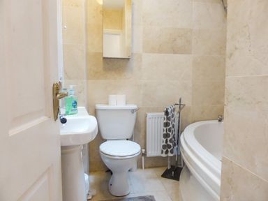 A bathroom with a toilet sink bathtub towel and mirror at Beach View in Duncannon near Ramsgrange County Wexford