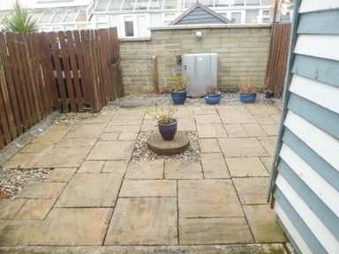 A fenced patio area with stone paving and potted plants at Beach View in Duncannon near Ramsgrange County Wexford
