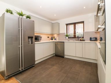 A kitchen with a stainless steel refrigerator microwave dishwasher and blue toaster at Iroko in Millbrook