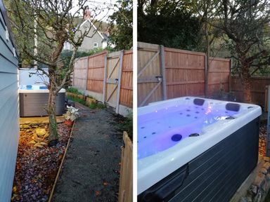 An outdoor area with a hot tub next to a wooden fence and a tree at Caban Glas in Llanafan near Pontrhydfendigaid