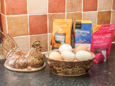 A kitchen counter with a ceramic hen container a dish with eggs and packets of cornish coffee tea and dog treats at Wagtail in Bradworthy near Bude