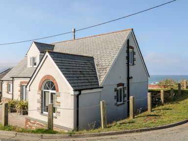 A house with a tiled roof near the coast with a view of the sea at Seagull Cottage in Bude