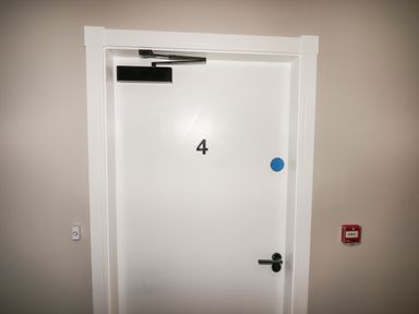 A white door with the number 4 and a black door closer at The Poppy Fields Abode in Dyserth