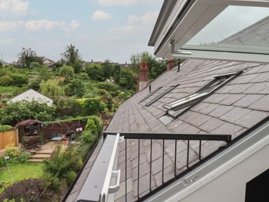 A view from an open roof window showing a garden and houses in the background at The Sigma Penthouse in Dyserth