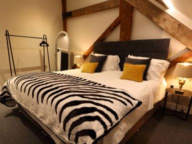 A bedroom with a bed pillow lamps and a mirror at The Sigma Penthouse in Dyserth