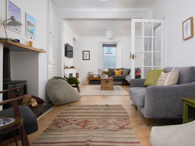 A living room with sofas cushions a coffee table and a rug at Saltwater Cottage in Babbacombe