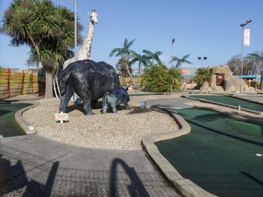 An outdoor mini golf course with artificial animals including a giraffe and hippos at 14 Fairways in Burnham-On-Sea
