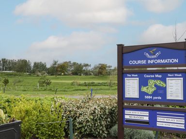 Golf course information sign with course map and rules next to a green golf field at 14 Fairways in Burnham-On-Sea