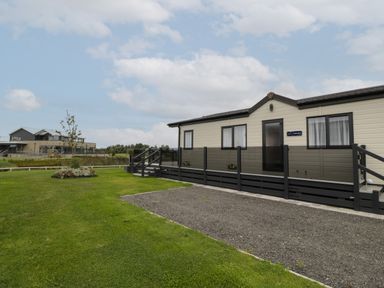 A static caravan with a small ramp and steps on a grassy plot at 14 Fairways in Burnham-On-Sea