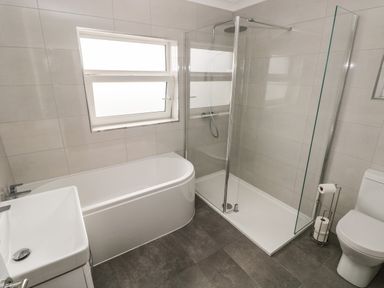 A bathroom with a bathtub sink shower and toilet at Larkhill in Tenby