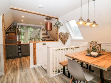 A kitchen with wooden countertops and a dining area with a wooden table and chairs at Lavender Lodge in St Ann's Chapel Cornwall