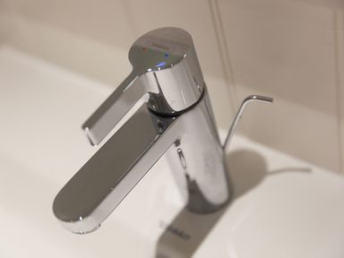 A chrome bathroom faucet with a lever handle on a white sink at Crystal Bay in St Ives