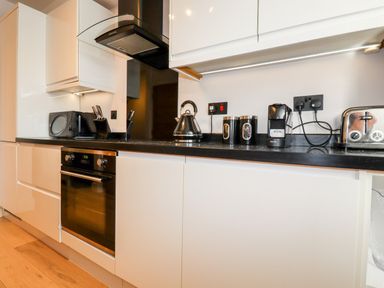 A kitchen countertop with a microwave kettle coffee machine toaster and knife set at 16 Ocean Heights in Newquay