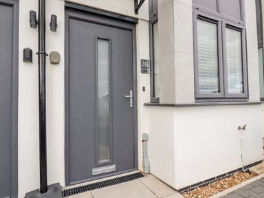 A grey front door with mail slot and handle next to a window with blinds at 16 Ocean Heights Newquay