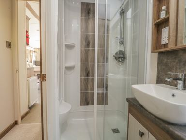 A bathroom with a shower enclosure sink and mirror cabinet at 22 Sherwood South Lakeland Leisure Village near Warton