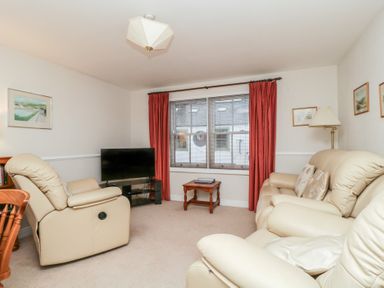 A living room with a television and seating at Derwent Haven in Keswick