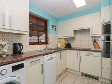 A kitchen with appliances and cabinets at Derwent Haven in Keswick