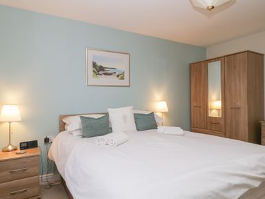 A bedroom with a bed and wardrobe at Derwent Haven in Keswick