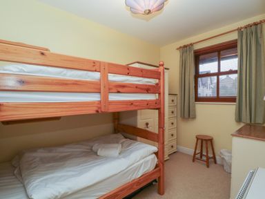 A bedroom with a bunk bed and a single bed at Derwent Haven in Keswick