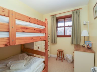 A bedroom with a bunk bed and dresser at Derwent Haven in Keswick