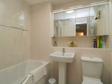 A bathroom with a bathtub, sink, and toilet at Derwent Haven, Keswick