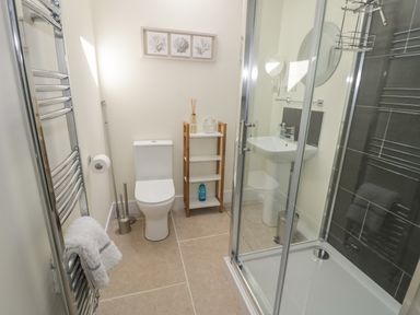 A bathroom with a toilet sink shower and towel rack at Garden Cottage in Upton Upon Severn
