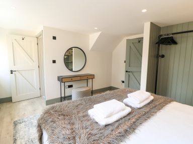 A bedroom with a bed and vanity at 12 Manor Farm Close Kingham