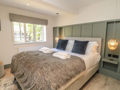 A bedroom with a bed and window at 12 Manor Farm Close Kingham