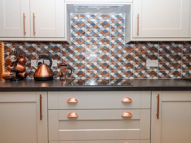 A kitchen countertop with copper kettle cups and coffee press against tiled backsplash at Bagtor Granary in Ilsington
