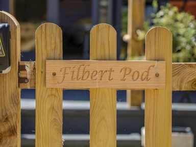 A wooden fence with a carved wooden sign reading Filbert Pod at Arundel West Sussex